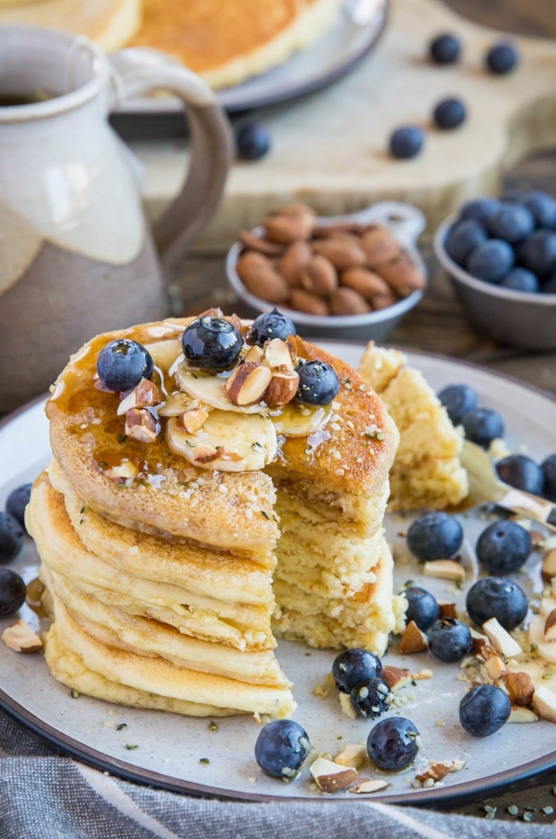 almond flour pancakes with toppings with a bite taken out, exposing the inside layers.