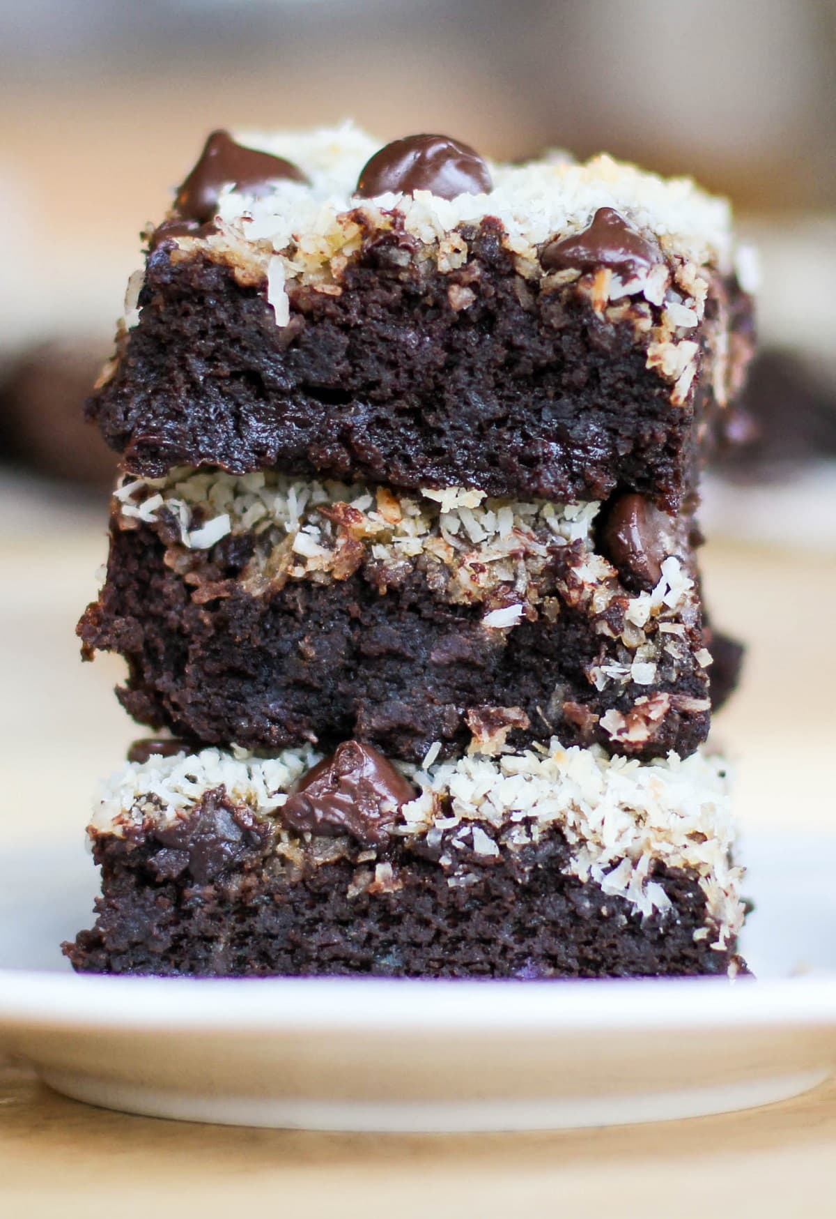 Stack of three black bean brownies on a plate, ready to eat.