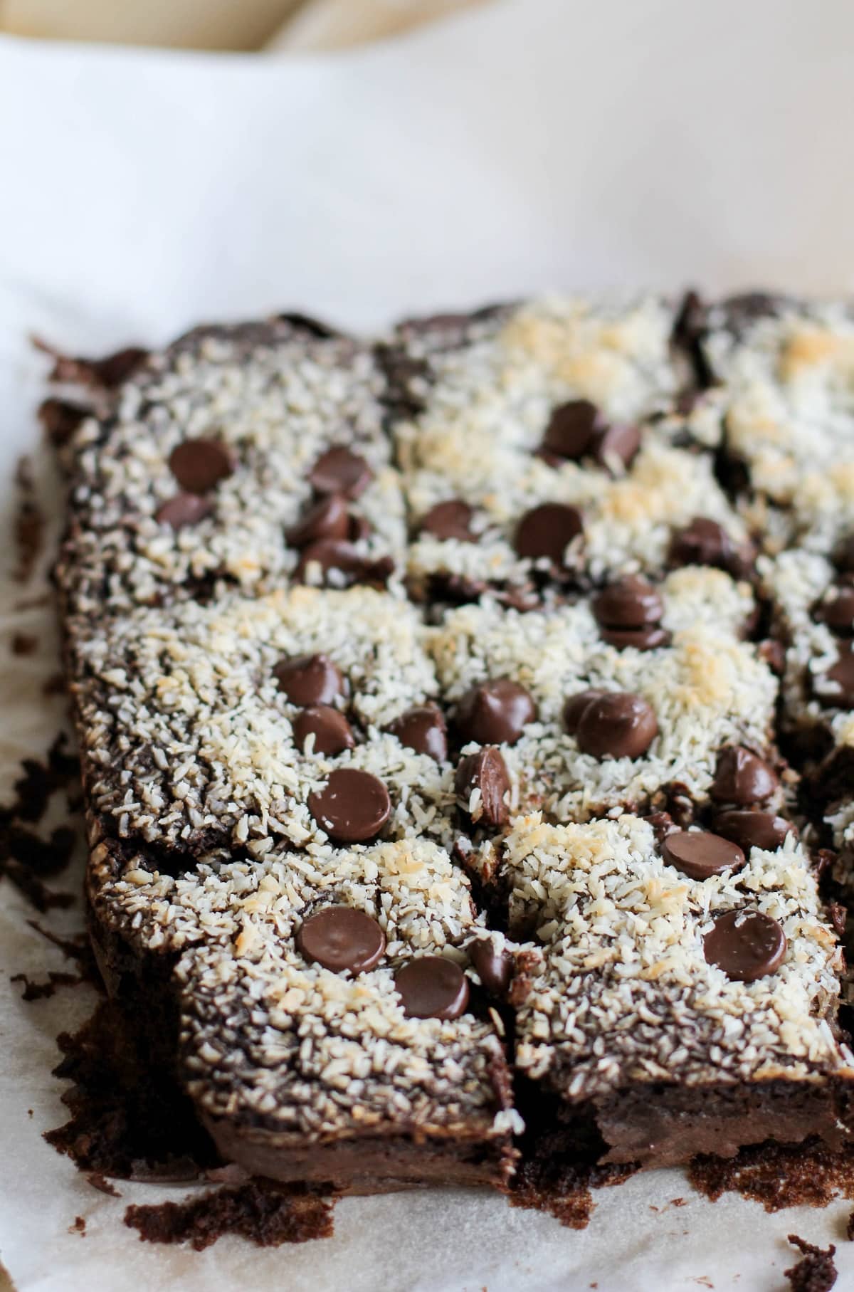 Batch of black bean brownies on a sheet of parchment paper, cut into slices.