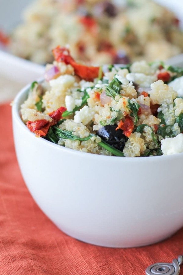 Mediterranean Quinoa Salad with spinach, kalamata olives, sun-dried tomatoes, feta, and lemon vinaigrette - a healthy vegetarian meal or side dish!