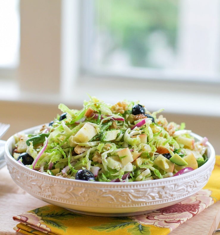 Shaved Brussels Sprouts Salad with avocado, apple, red onion, blueberries, walnuts, and citrus dressing | TheRoastedRoot.net #healthy #salad #sidedish #glutenfree #paleo #vegan
