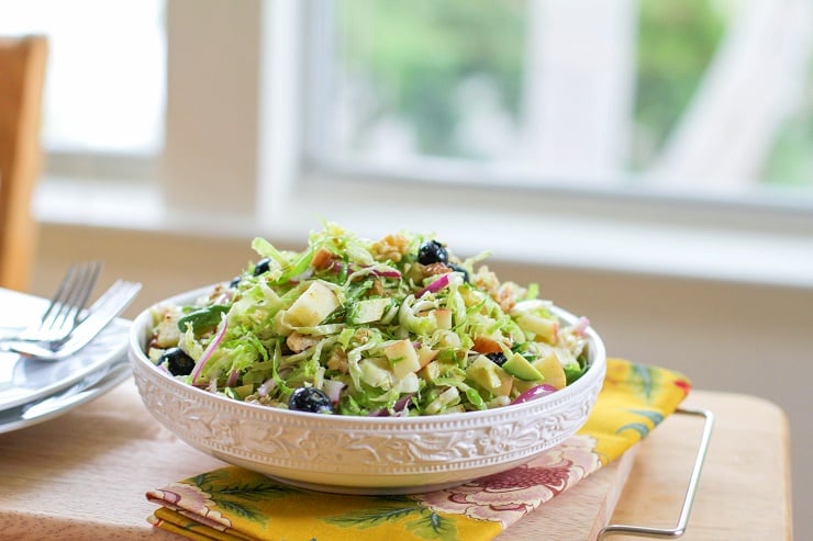 Shaved Brussels Sprouts Salad with avocado, apple, red onion, blueberries, walnuts, and citrus dressing | TheRoastedRoot.net #healthy #salad #sidedish #glutenfree #paleo #vegan