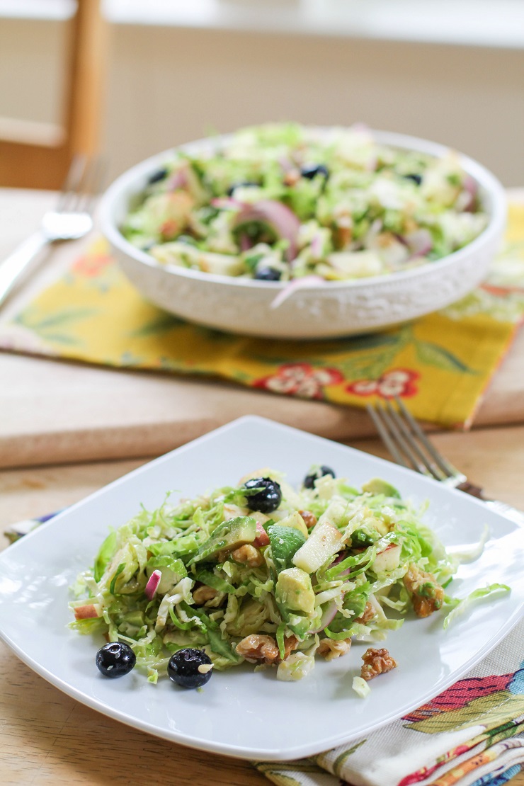 Shaved Brussels Sprouts Salad with avocado, apple, red onion, blueberries, walnuts, and citrus dressing | TheRoastedRoot.net #healthy #salad #sidedish #glutenfree #paleo #vegan