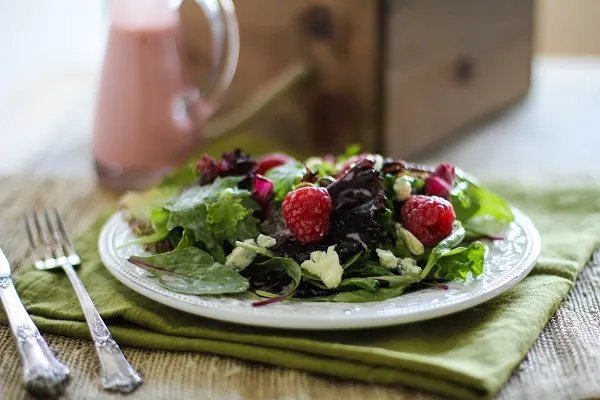 Raspberry Pistachio Salad with Creamy Raspberry Vinaigrette | https://www.theroastedroot.net