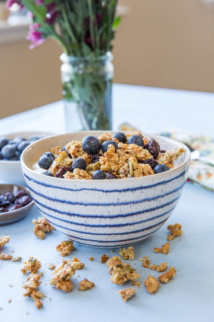 Maple-sweetened Grain-Free Paleo Granola made with nuts and seeds. This refined sugar-free recipe yields huge granola clusters and is super crunchy and delicious for breakfast