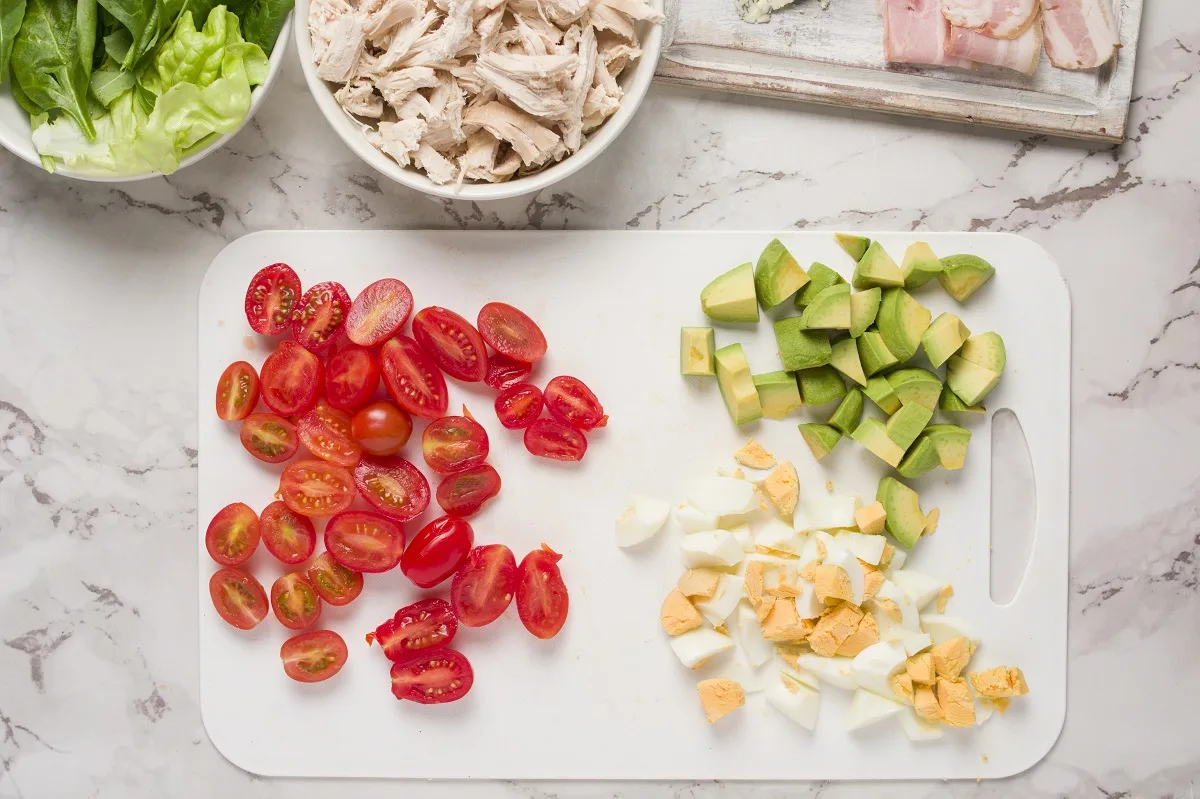 Ingredients for Cobb Salad on a cutting board, ready to be assembled into salad.