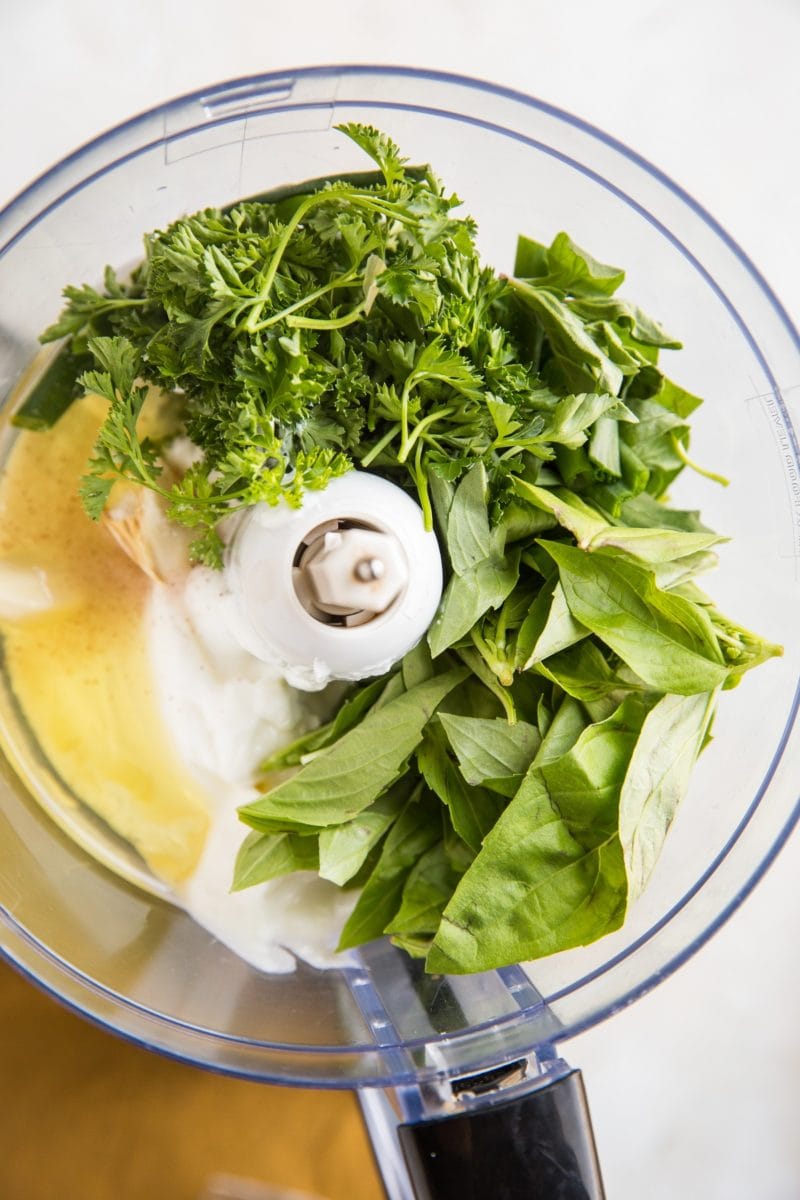 Ingredients for green goddess dressing in a food processor ready to be processed