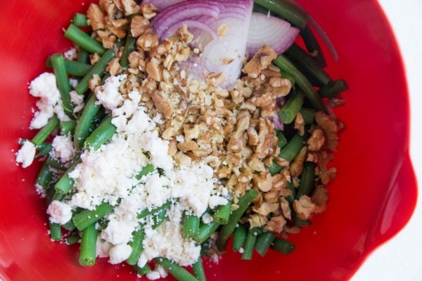 Ingredients for green bean salad in a mixing bowl