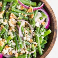 top down close up image of green bean salad in a wooden bowl