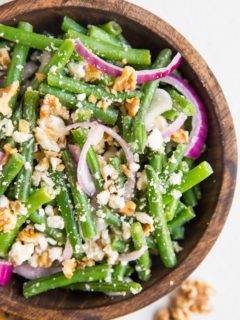 top down close up image of green bean salad in a wooden bowl