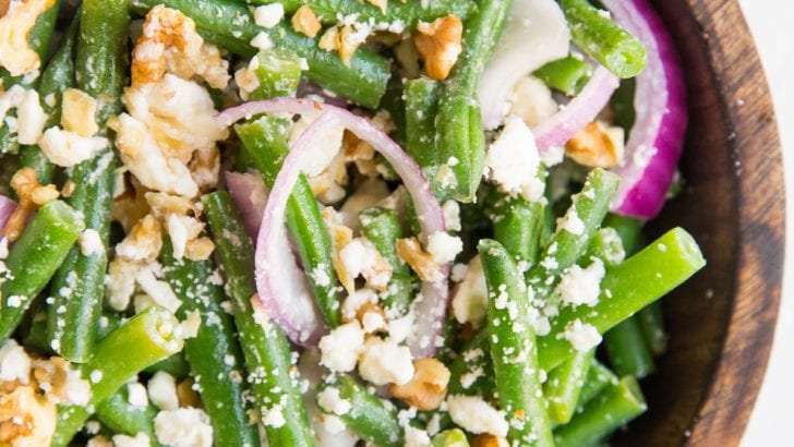 top down close up image of green bean salad in a wooden bowl