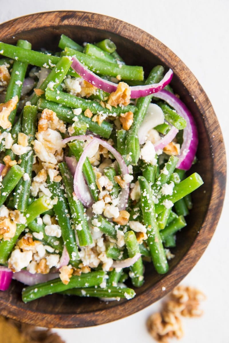 top down close up image of green bean salad in a wooden bowl