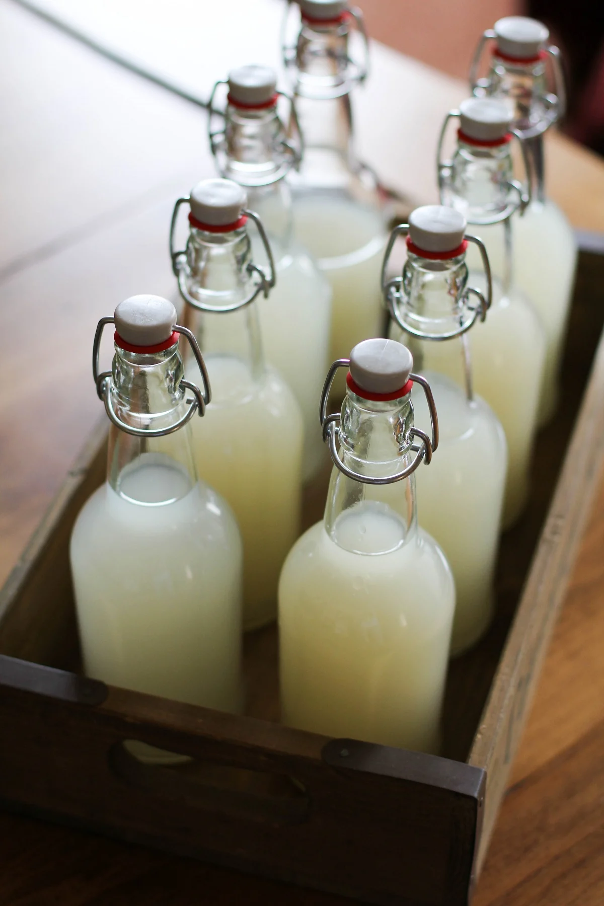 Rustic wooden serving crate with 8 bottles of homemade ginger beer