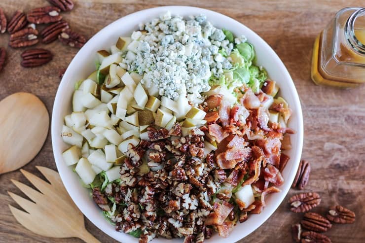 Brussel Sprout Chopped Salad with bacon, pears, candied pecans, blue cheese, and maple-bacon vinaigrette | TheRoastedRoot.com