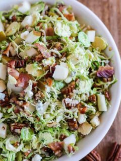 Brussel Sprout Chopped Salad with bacon, pears, candied pecans, blue cheese, and maple-bacon vinaigrette | TheRoastedRoot.com