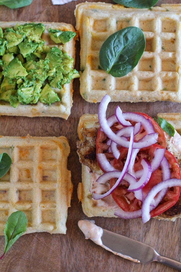 Gluten Free Jalapeño Cheddar Bacon Waffle Sandwiches with gluten-free fried chicken, mashed avocado, and chipotle yogurt sauce