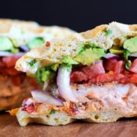 Gluten Free Jalapeño Cheddar Bacon Waffle Sandwiches with gluten-free fried chicken, mashed avocado, and chipotle yogurt sauce