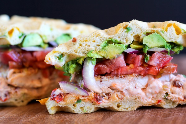 Gluten Free Jalapeño Cheddar Bacon Waffle Sandwiches with gluten-free fried chicken, mashed avocado, and chipotle yogurt sauce
