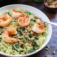 Bowl of pesto spaghetti squash with sautéed shrimp on top.