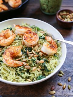 Bowl of pesto spaghetti squash with sautéed shrimp on top.