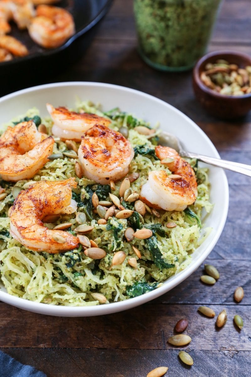 Bowl of pesto spaghetti squash with sautéed shrimp on top.