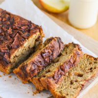 Loaf of apple bread on a cutting board, sliced into individual slices