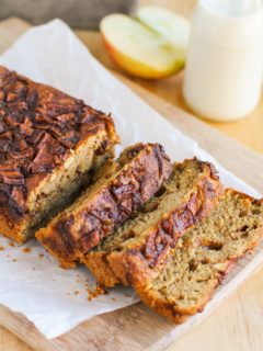 Loaf of apple bread on a cutting board, sliced into individual slices