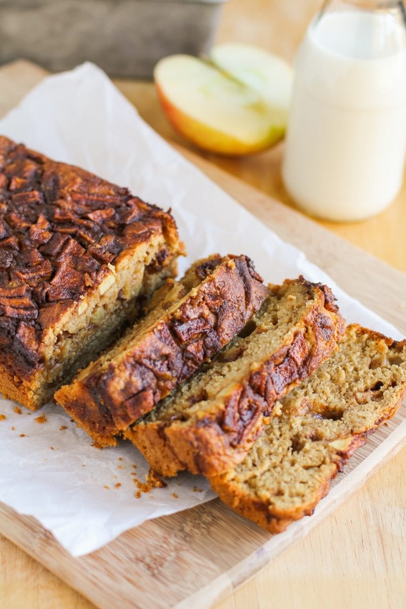 Loaf of apple bread on a cutting board, sliced into individual slices