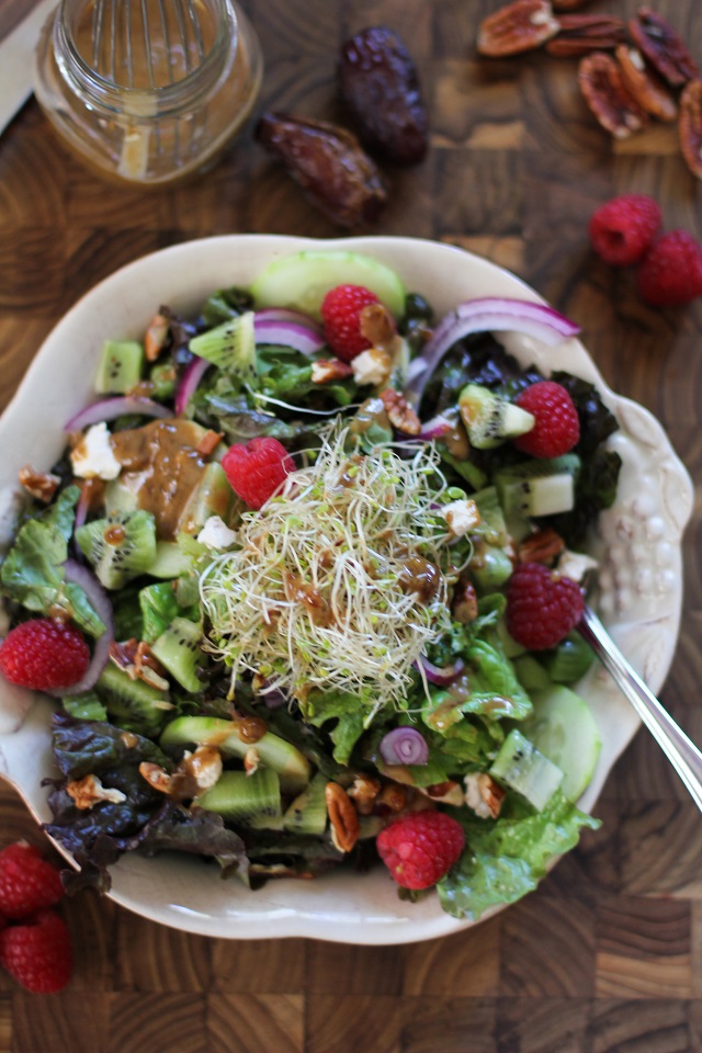 Spring Green Salad with kiwi, raspberries, cucumbers, sprouts, pecans, and date-balsamic vinaigrette | theroastedroot.net #vegetarian #recipe #healthy