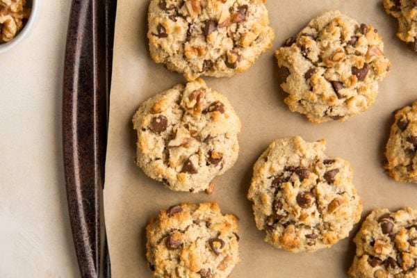 Horizontal photo of cookie sheet with paleo chocolate chip cookies on a sheet of parchment paper