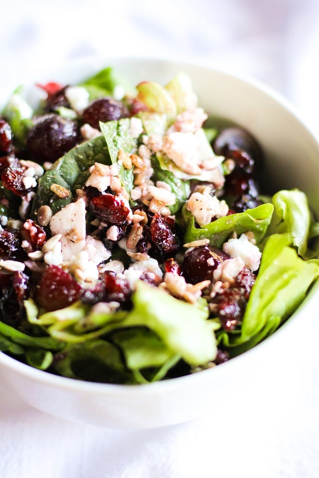 Spinach Salad with sunflower seeds, dried cranberries, grapes, feta cheese, and raspberry vinaigrette | TheRoastedRoot.net #healthy #recipe #vegetarian