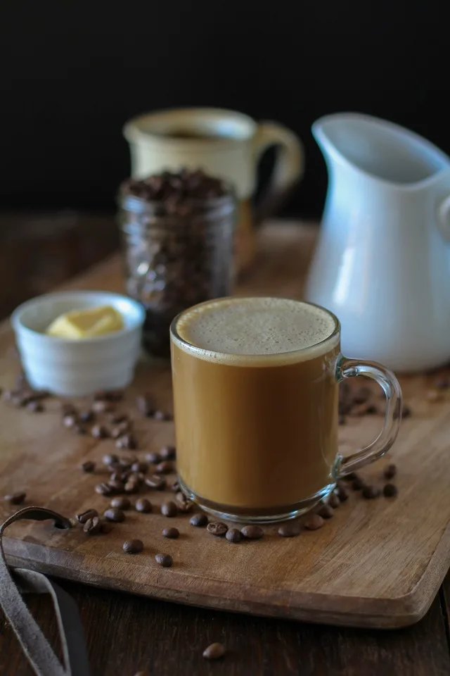 Bulletproof Coffee - brewed coffee + grassfed butter + coconut oil blended together in a blender makes a frothy latte! | TheRoastedRoot.net #paleo #recipe #healthy #drink
