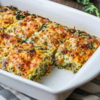 Sweet potato and sausage egg casserole in a baking dish with a piece missing, fresh out of the oven.