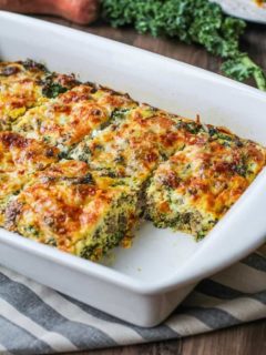 Sweet potato and sausage egg casserole in a baking dish with a piece missing, fresh out of the oven.