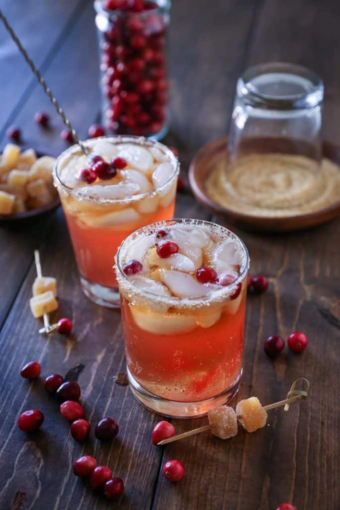 Cranberry Dark and Stormy cocktails on a wooden table, ready to drink.