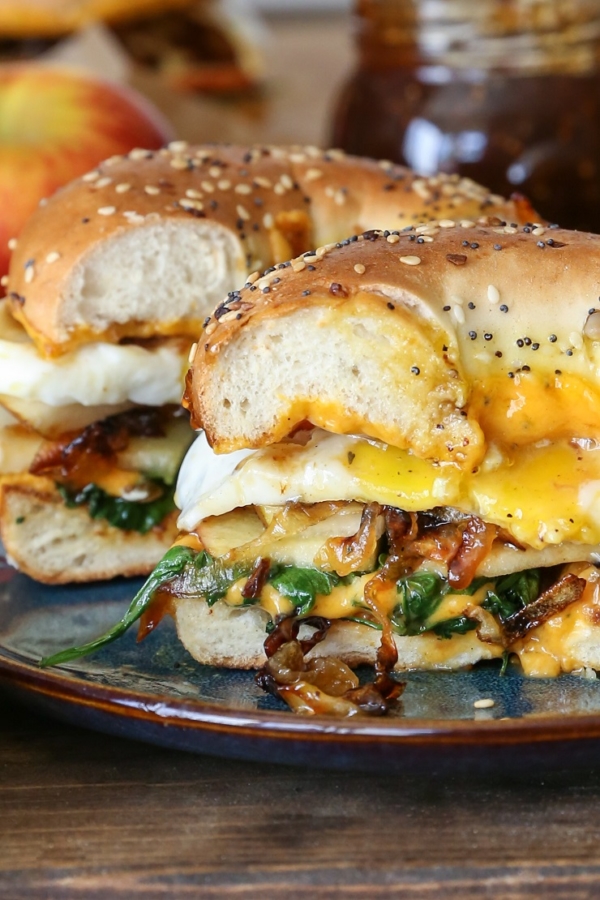 Pear Apple Cheddar Caramelized Onion Grilled Cheese Bagel Sandwiches on a plate with gooey cheese.