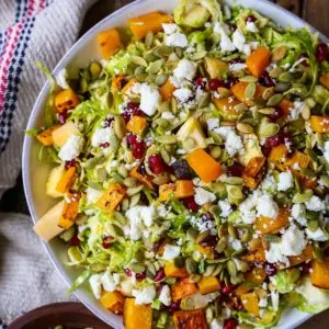 Shaved Brussel Sprout Salad with Roasted Butternut Squash, Pomegranate Seeds, Pumpkin Seeds, Feta, and Citrusy Maple Cinnamon Dressing | TheRoastedRoot.net #healthy #salad #vegetarian #gltuenfree #sidedish #thanksgiving