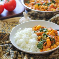 Bowl of vegan curry with basmati rice on a decorative napkin.