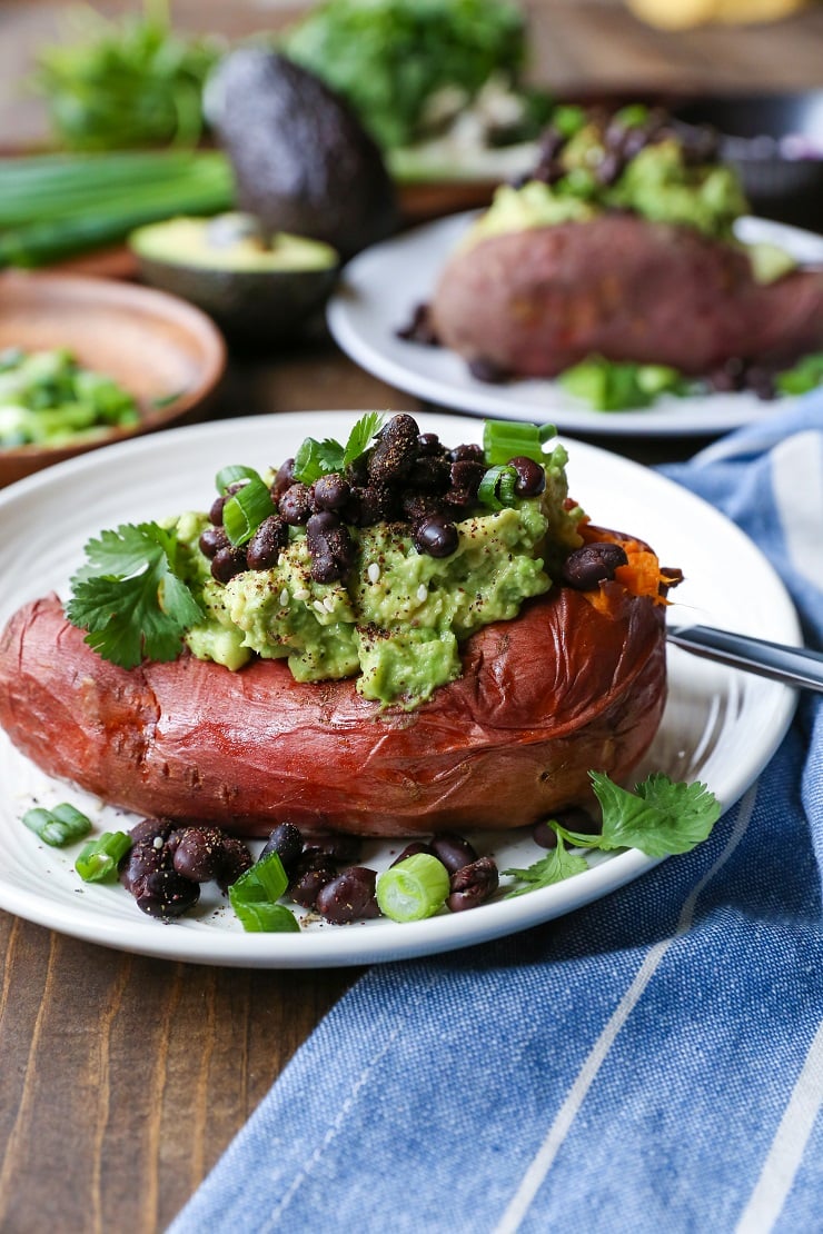 Guacamole and Black Bean Loaded Sweet Potatoes | TheRoastedRoot.net #healthy #glutenfree #recipe #vegan #vegetarian