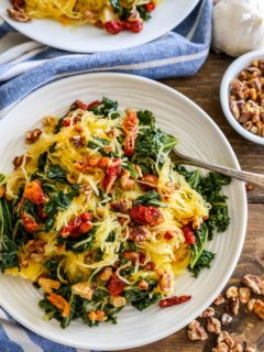 Top down photo of a white plate of Roasted Garlic and Kale Spaghetti Squash with Sun-Dried Tomatoes