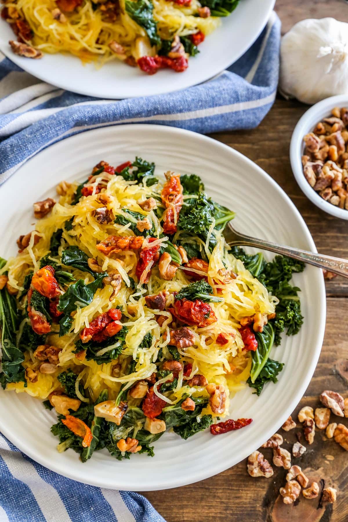 Top down photo of a white plate of Roasted Garlic and Kale Spaghetti Squash with Sun-Dried Tomatoes