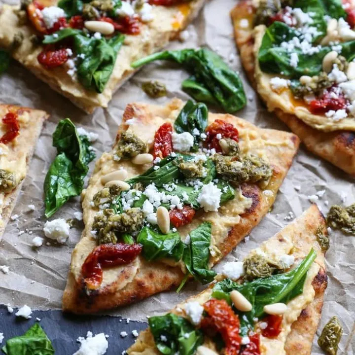 Hummus Flatbread with Sun-Dried Tomatoes, Spinach, Pesto, and Feta Cheese - a delicious healthy appetizer or meal