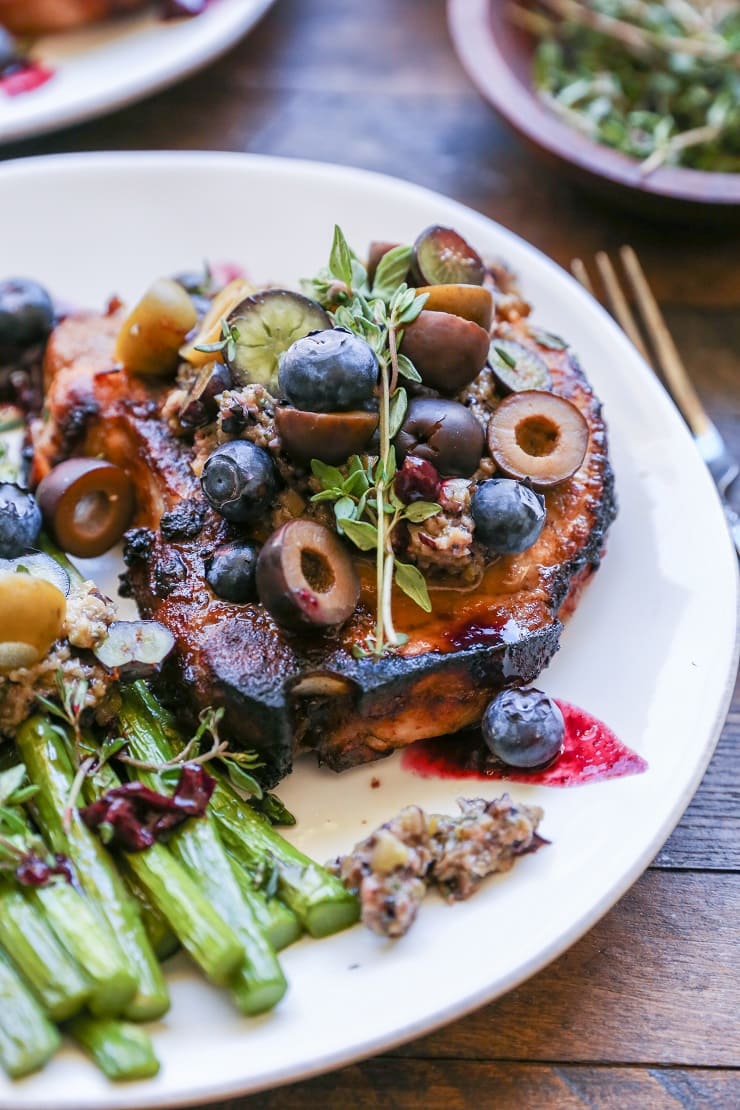 Maple Balsamic Pork Chops with Blueberry Olive Tapenade - an easy paleo dinner recipe that only requires 30 minutes and a few ingredients to prepare.