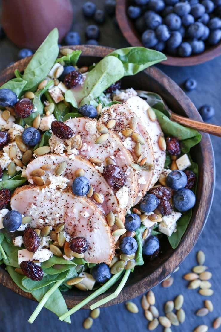 Baked Chicken Spinach Salad with dried cranberries, blueberries, feta cheese, roasted pumpkin seeds, and raspberry vinaigrette - a healthy lunch or dinner recipe