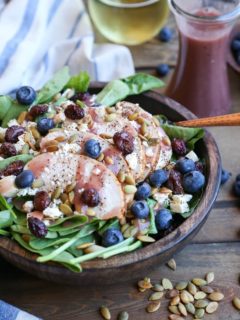 Baked Chicken Spinach Salad with dried cranberries, blueberries, feta cheese, roasted pumpkin seeds, and raspberry vinaigrette - a healthy lunch or dinner recipe