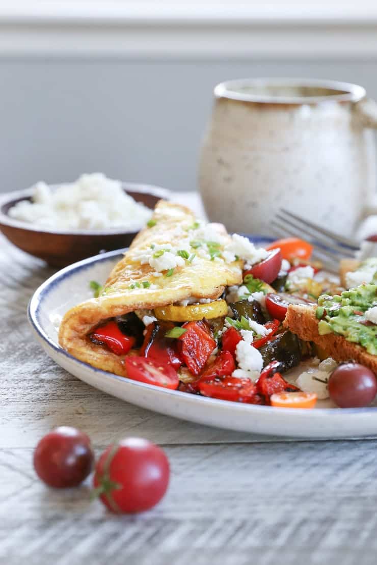 Late Summer Balsamic Roasted Vegetable Omelettes - this veggie-packed omelette includes zucchini, yellow squash, bell pepper, tomatoes, chives, and feta cheese for a winning breakfast.