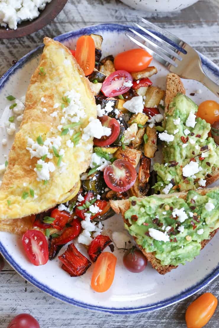 Late Summer Balsamic Roasted Vegetable Omelettes - this veggie-packed omelette includes zucchini, yellow squash, bell pepper, tomatoes, chives, and feta cheese for a winning breakfast.