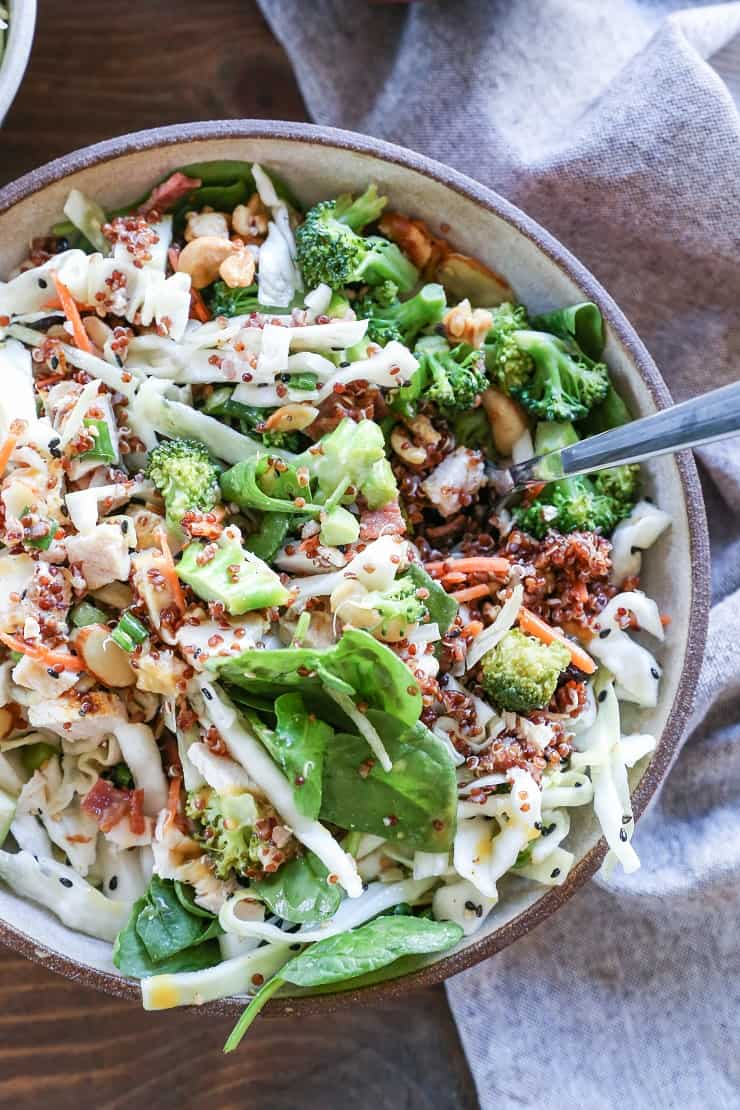 Detox spinach salad with quinoa, broccoli, cabbage, cashews, bacon, dried cranberries, and orange-ginger dressing #paleo #healthy #saladrecipe