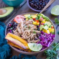 Crock Pot Carnitas Burrito Bowls with mango salsa, black beans, fried plantains, and shredded cabbage