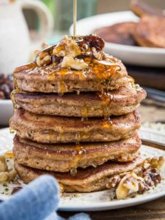 close up stack of paleo carrot cake pancakes with honey being drizzled on top